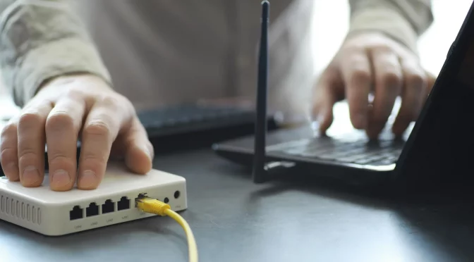 pessoa realizando e configurando um modem de internet após a contratação de serviço de um provedor de internet regional
