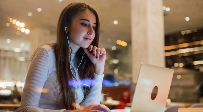 Mulher branca em frente ao computador trabalhando em um dos melhores ISP’s do país